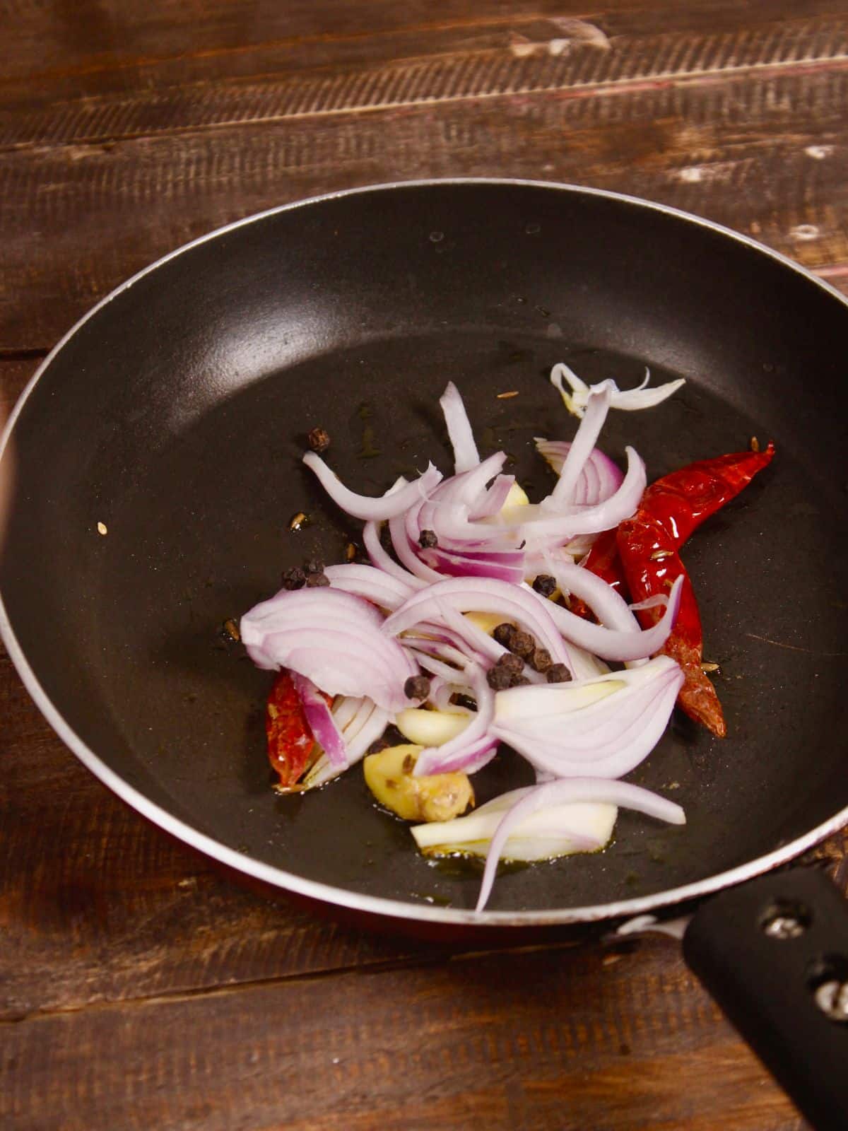 add sliced onions and black peppers to the pan  