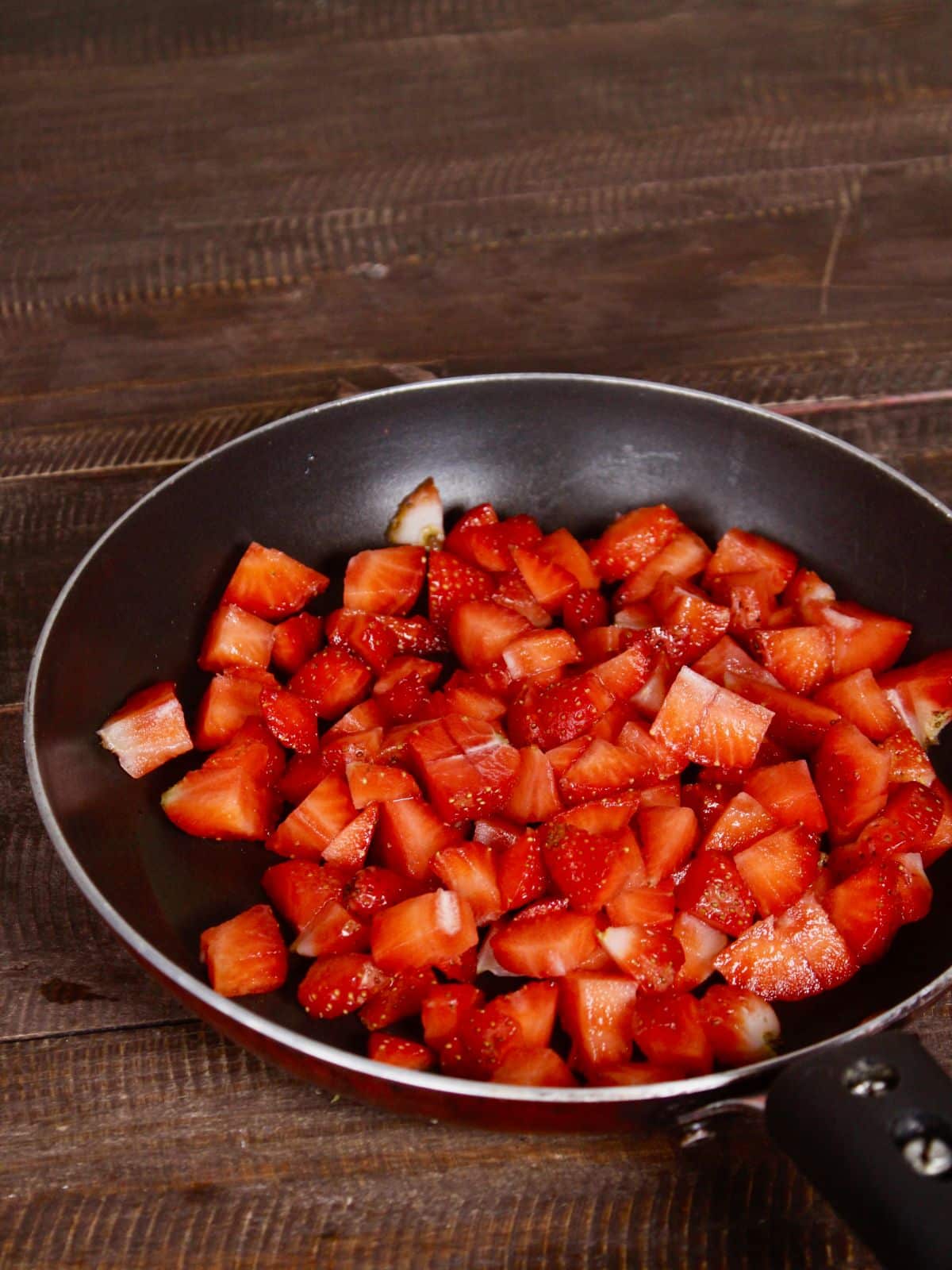take chopped strawberries in a pan 