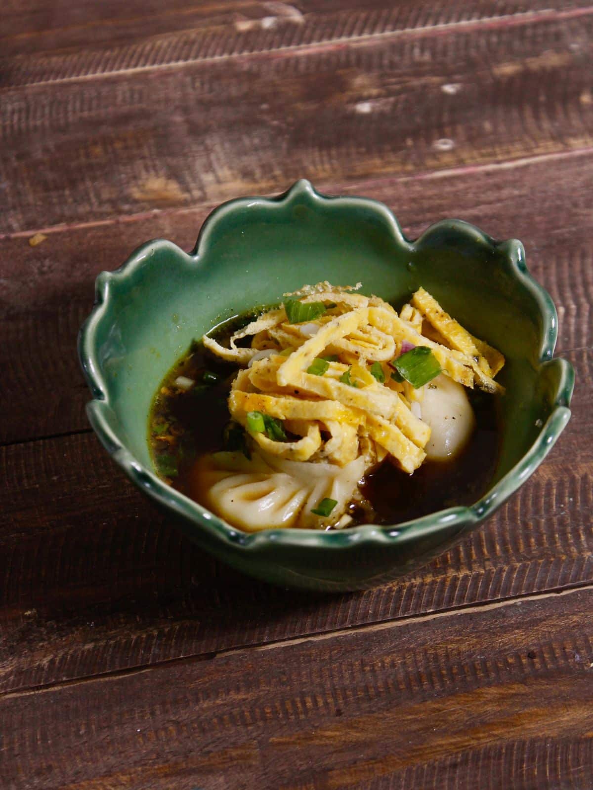garnish Korean Dumpling Soup with egg and chopped green onions and enjoy 
