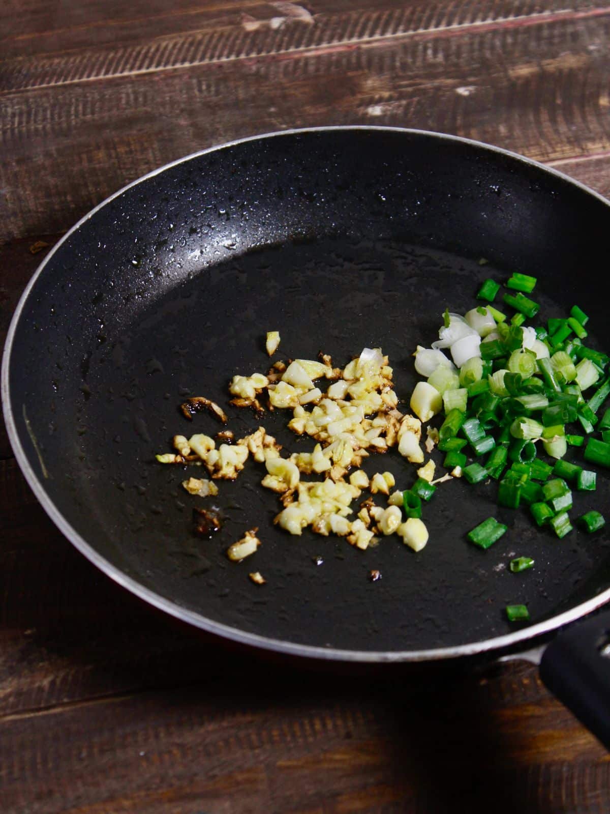 add green onions and spices to the pan and mix well