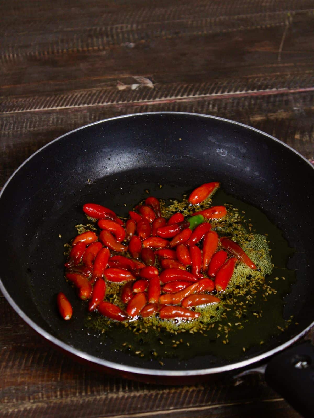 Add red chillies to the pan and saute 