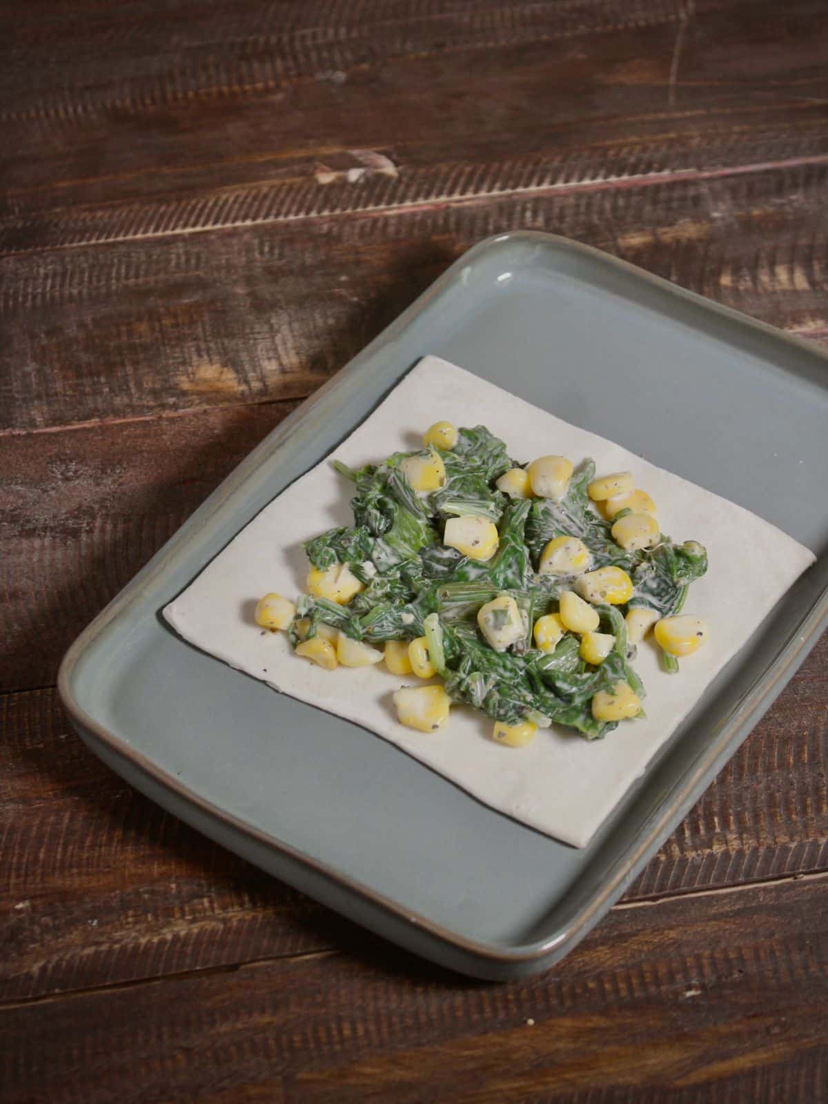 add some corn spinach mixture over the top of the pastry sheet 