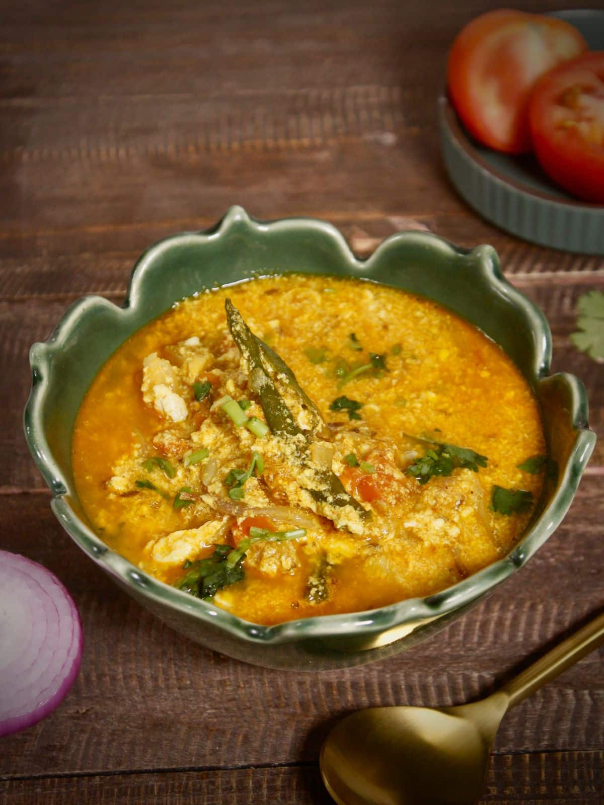 garnish Assamese style tomato egg curry with some coriander leaves and serve with rice or rotis