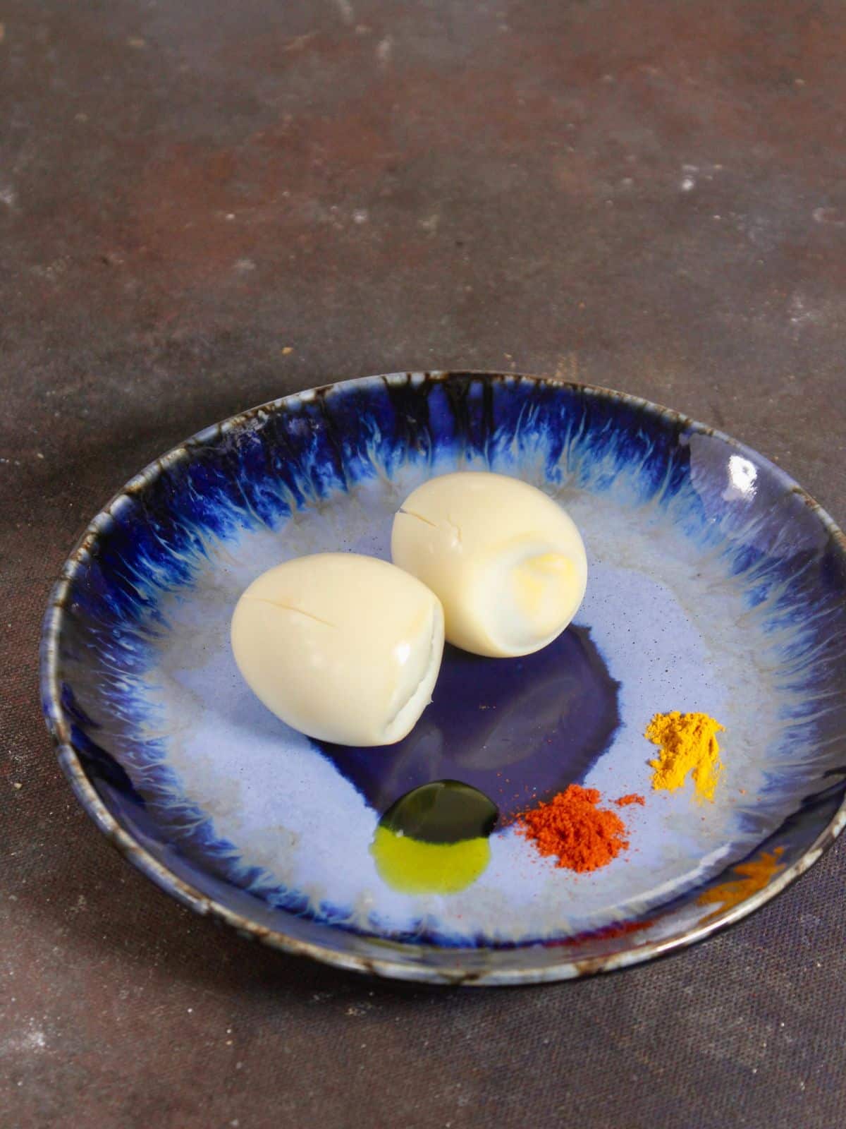 take boiled eggs with powdered spices on a plate 