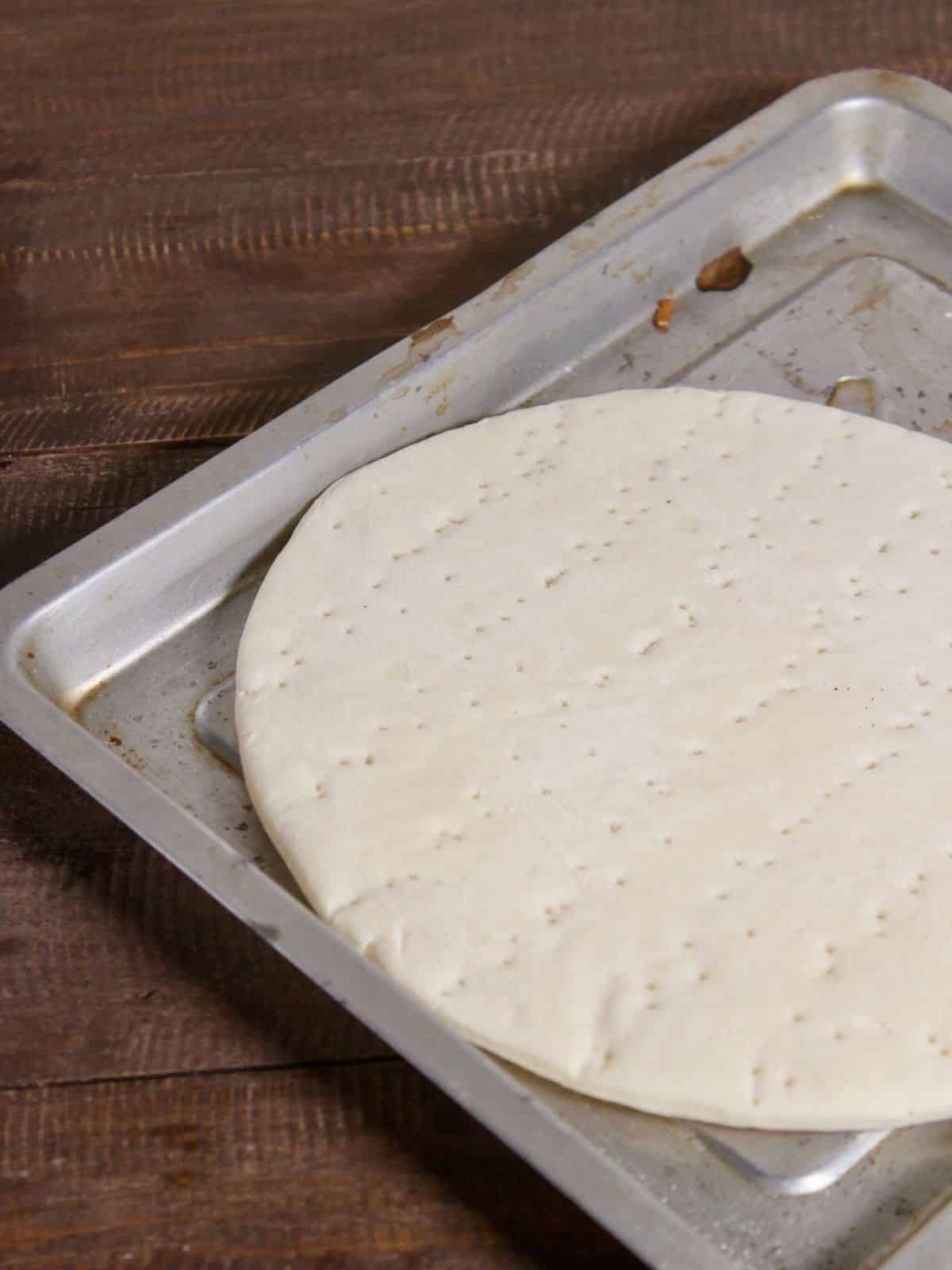 take pizza base on a baking tray 