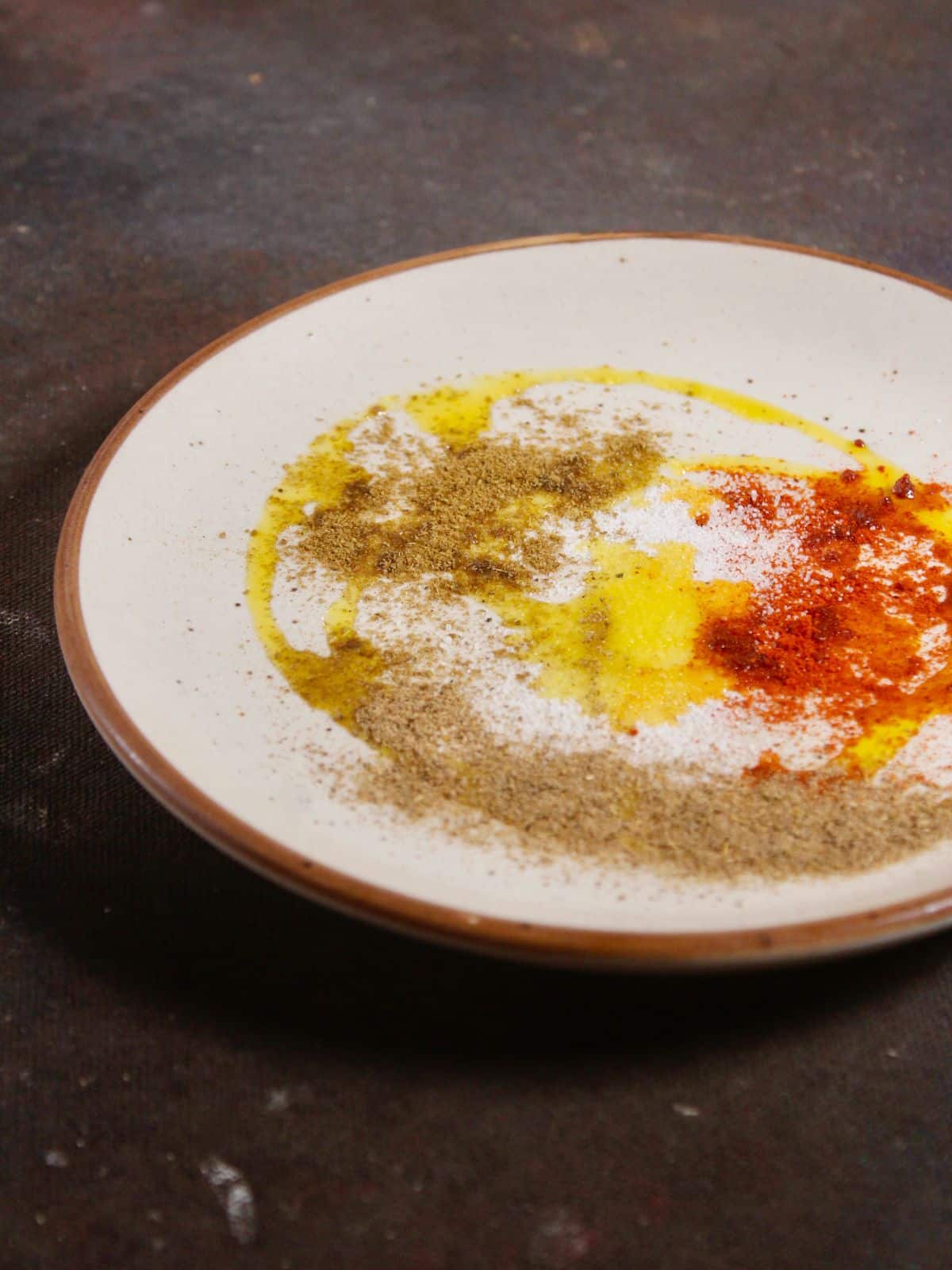 take mustard oil with powdered spices on a plate 