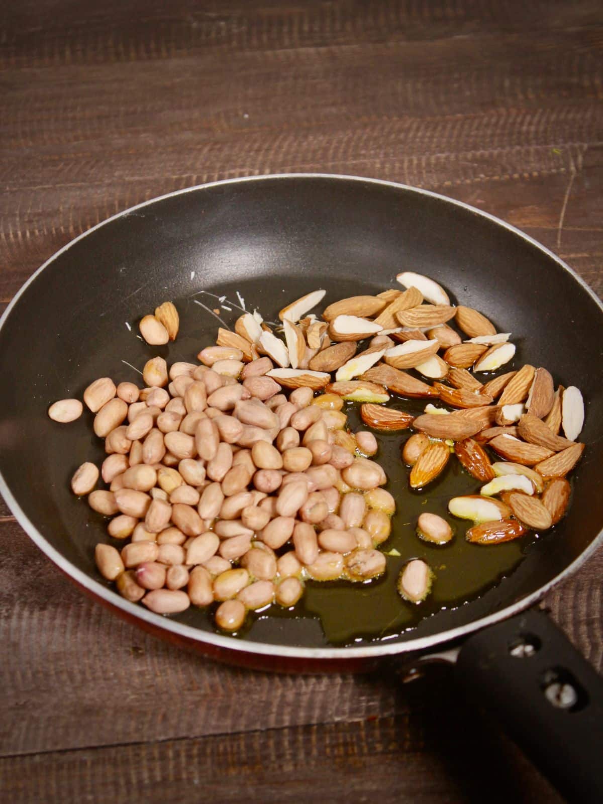 add oil, peanuts and almonds in a pan and saute 