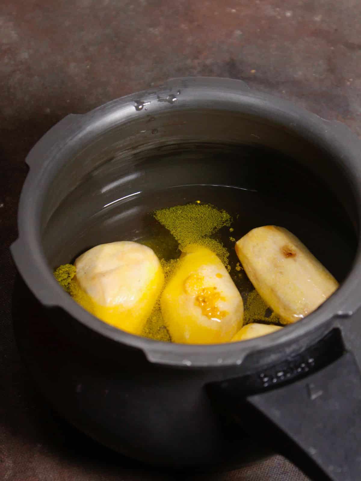 add yams along with turmeric into the pressure cooker and start boil