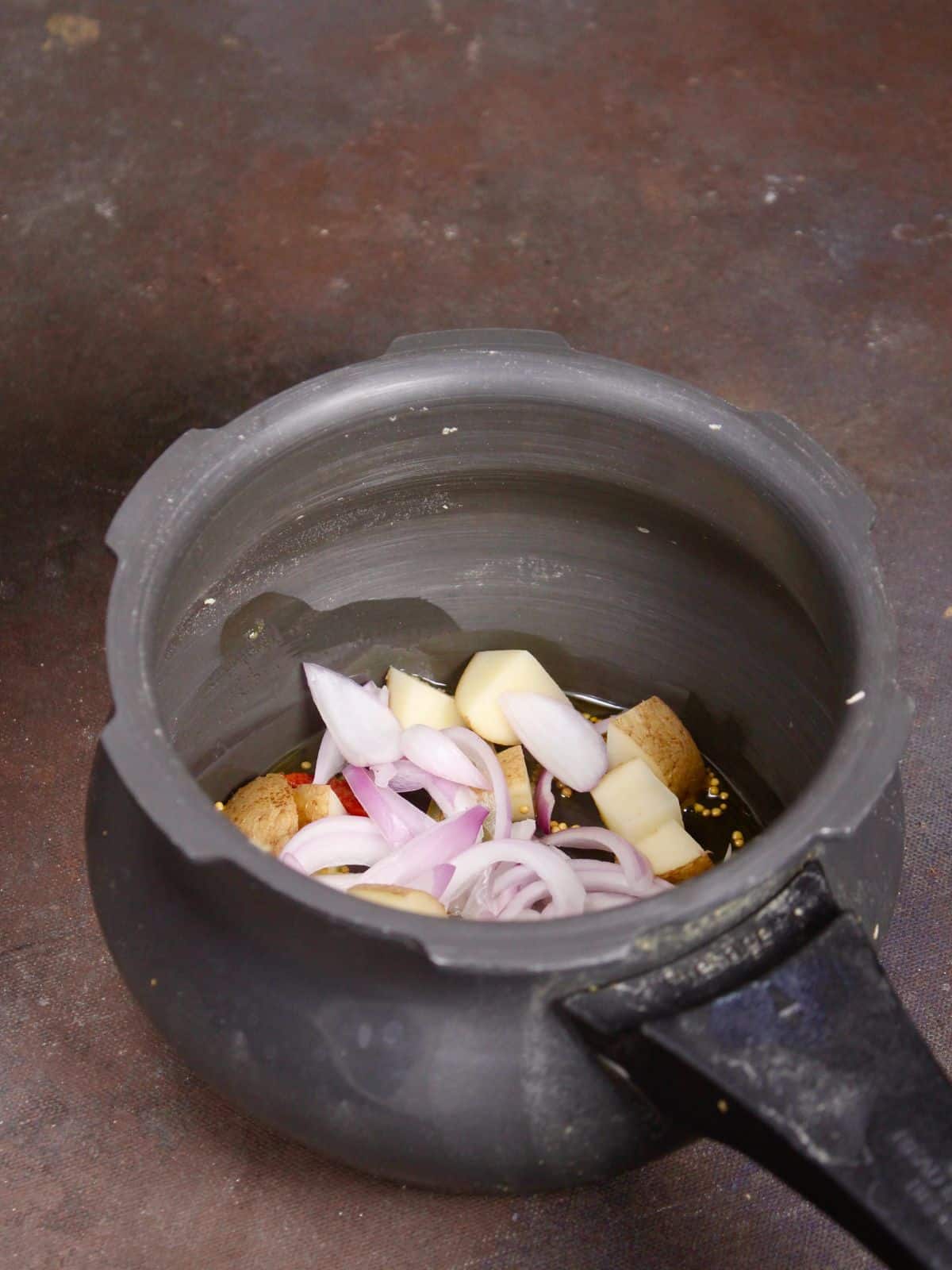 add onions and potatoes to the cooker  