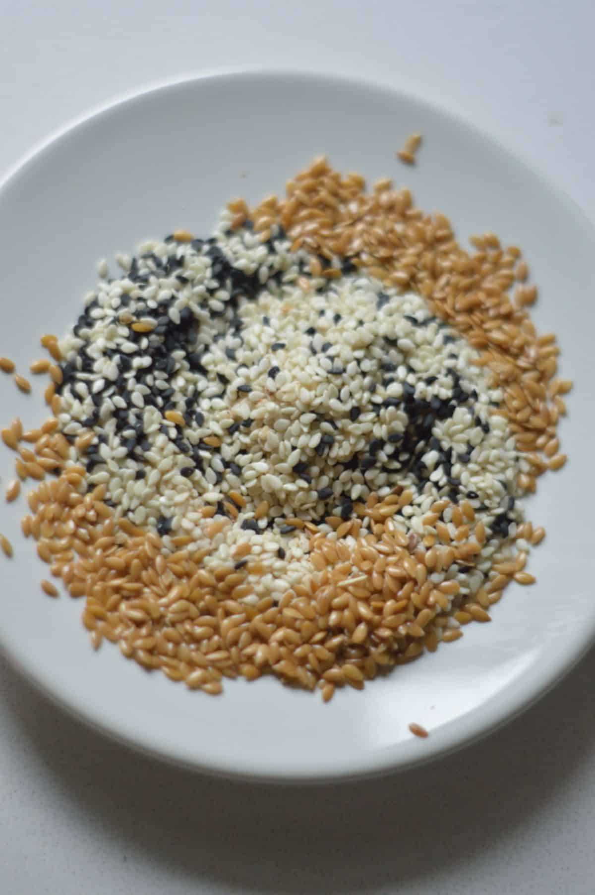 MIxed seeds on a white plate.