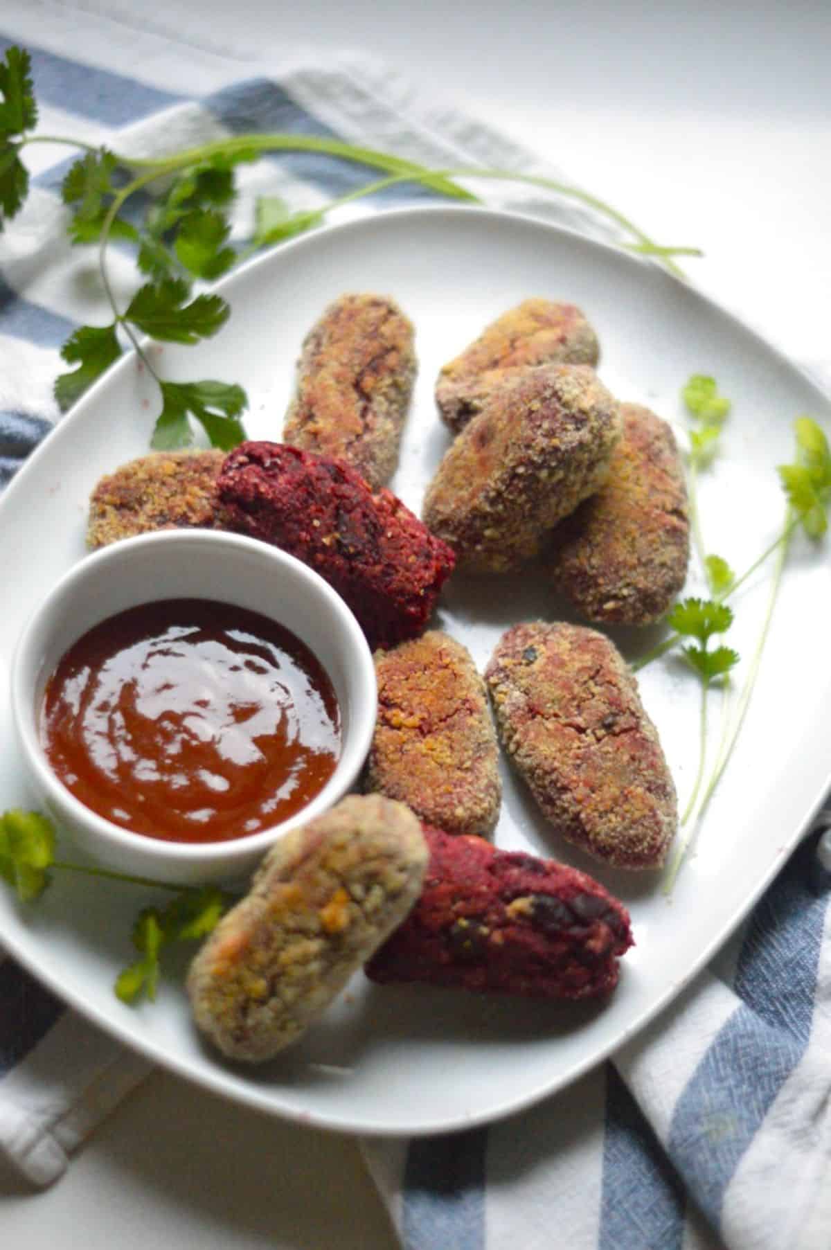 Air Fryer Veggie Cutlets with a bowl of dip on a white tray.