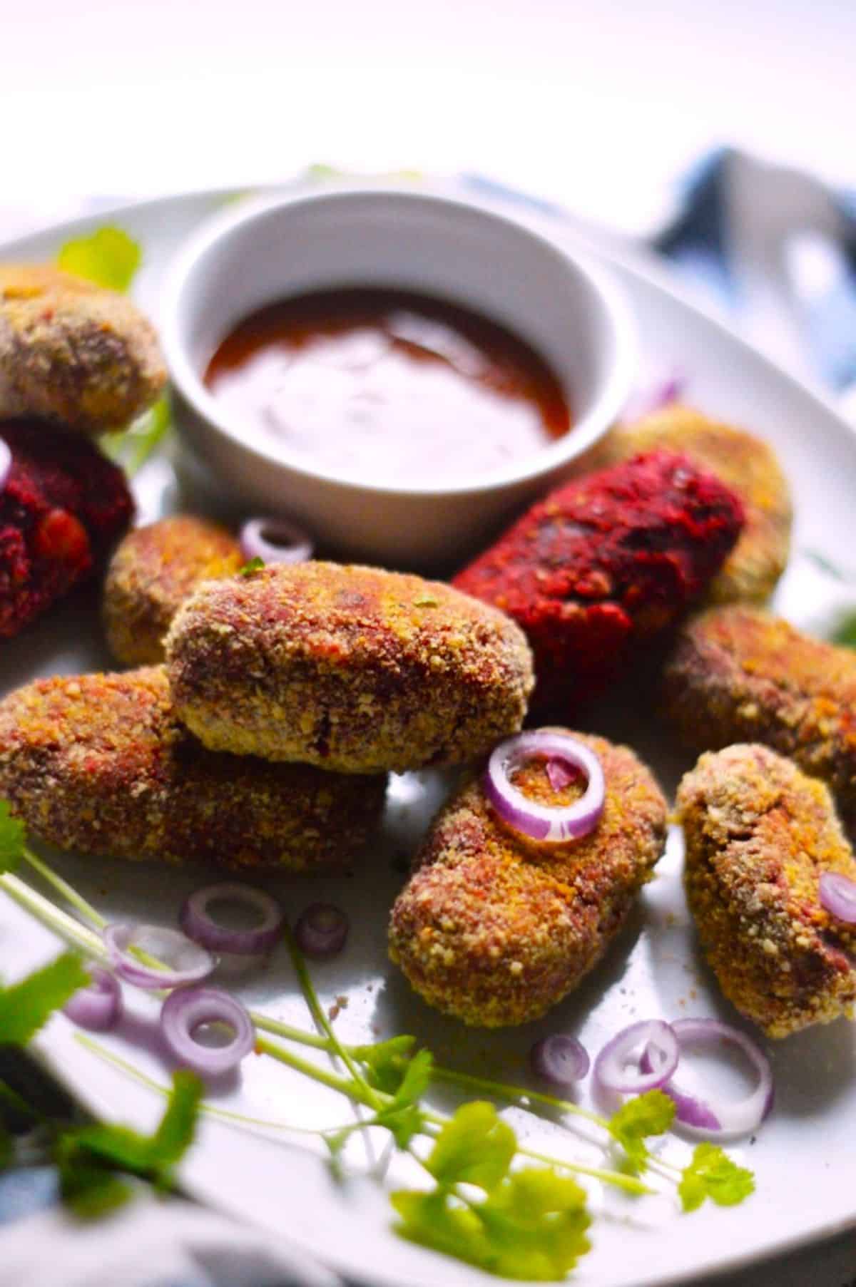 Air Fryer Veggie Cutlets with a bowl of dip on a white tray.