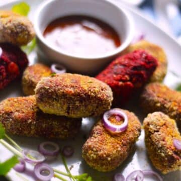 Air Fryer Veggie Cutlets with a bowl of dip on a white tray.