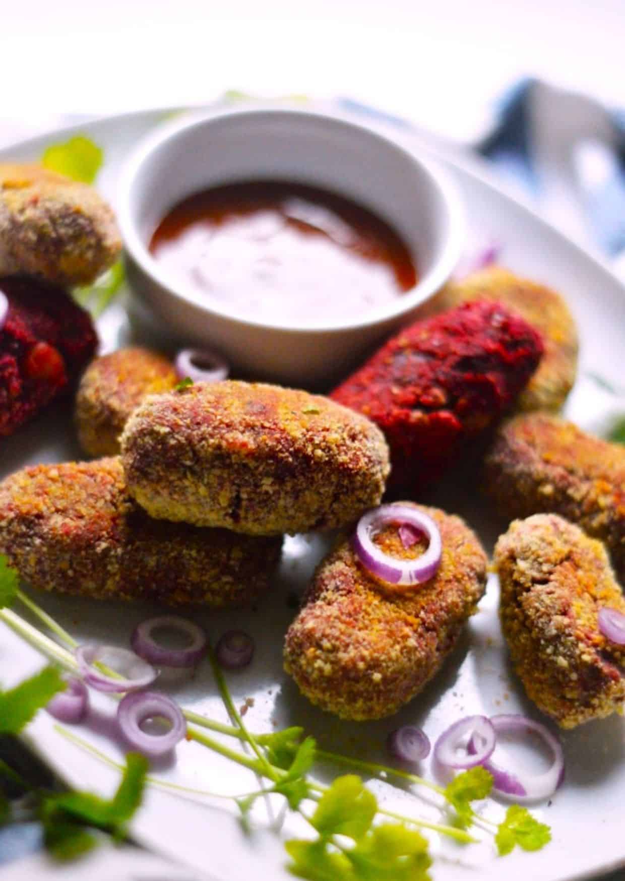 Air Fryer Veggie Cutlets with a bowl of dip on a white tray.