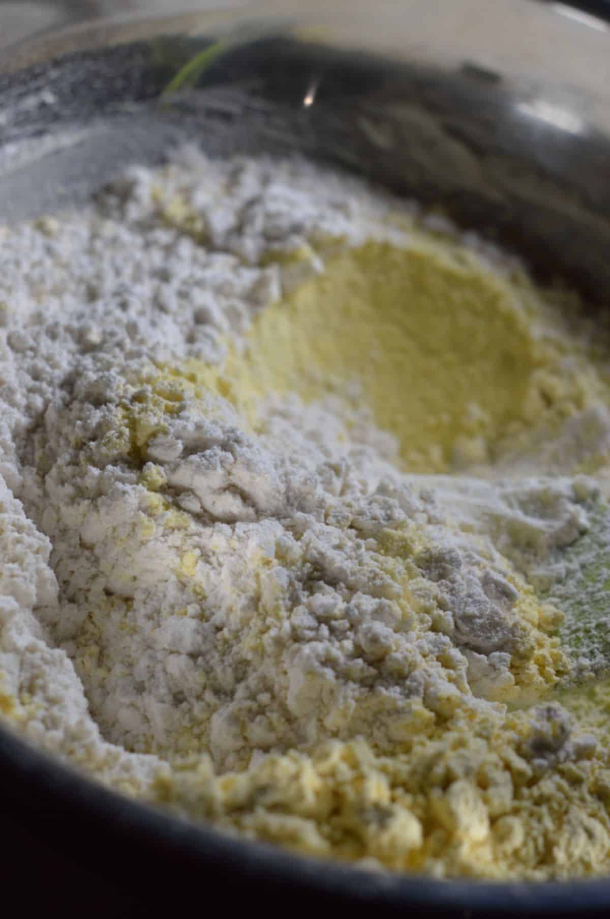 Almond flour, powdered sugar, baking powder, and cardamom powder in a bowl.