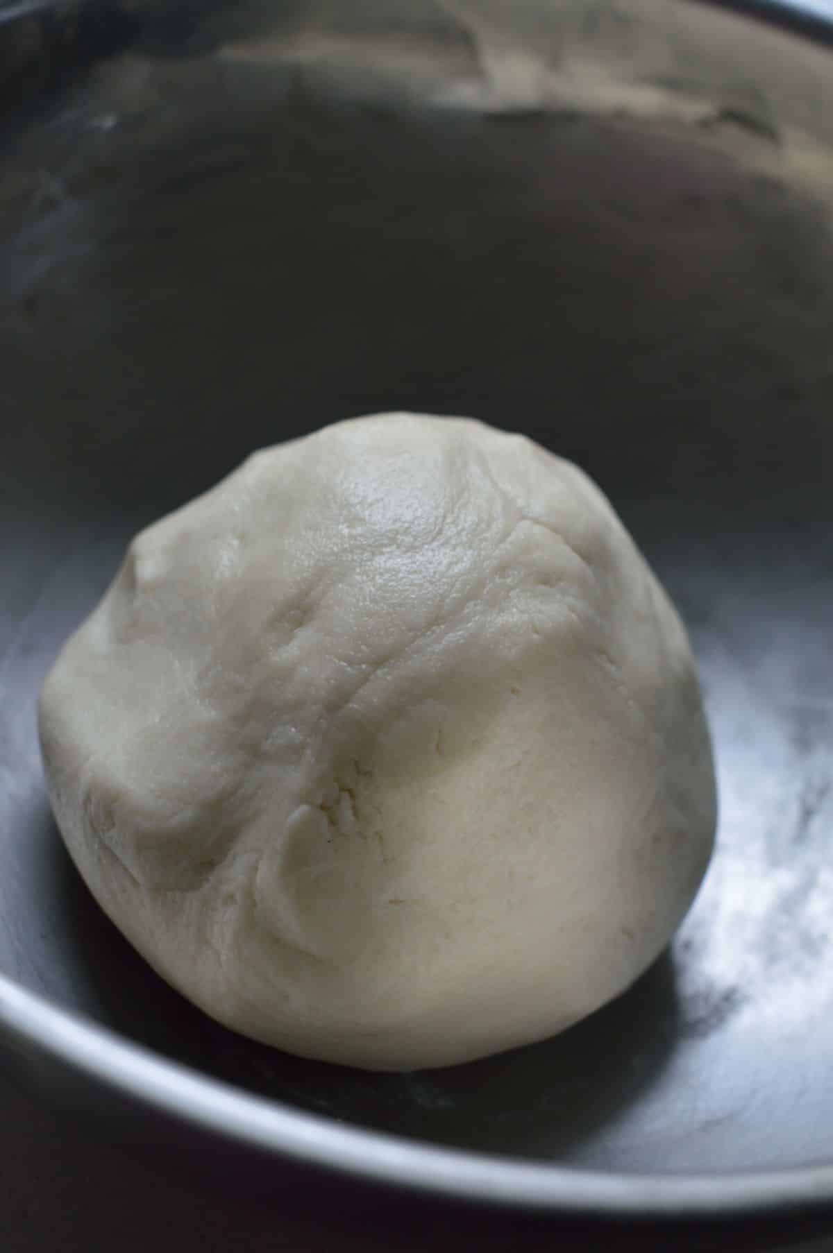 A ball-shaped cookie dough in a bowl.