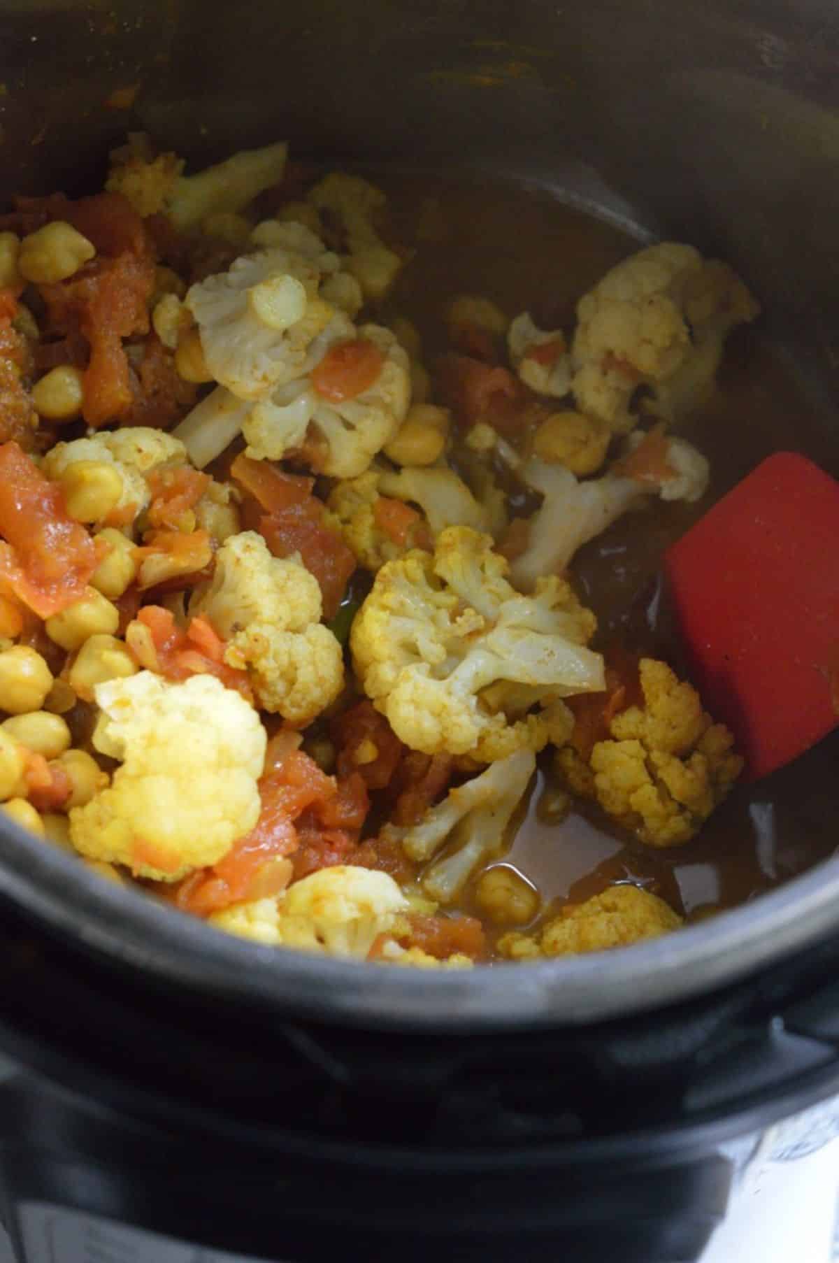 Chana Gobi Masala dish cooking in a pot.