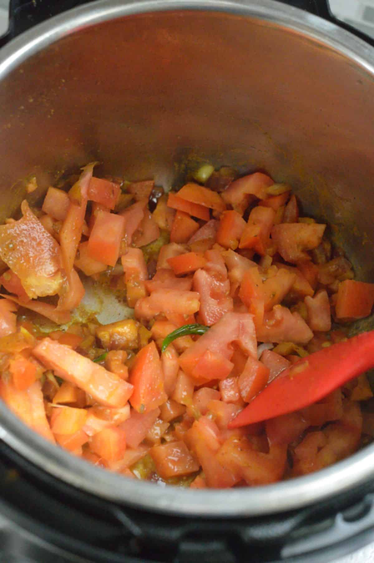 Cooking chopped tomatoes in a pot.