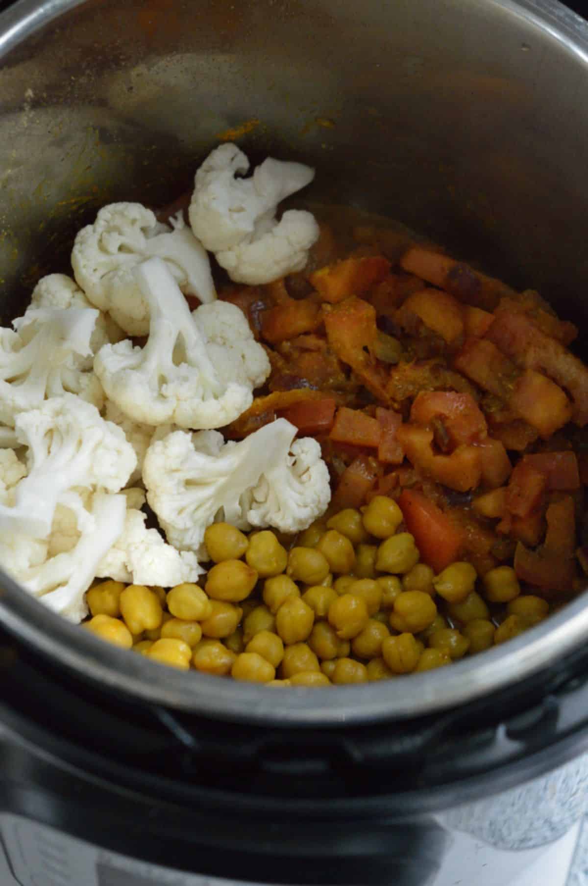 Cooking Chana Gobi Masala ingredients in a pot.