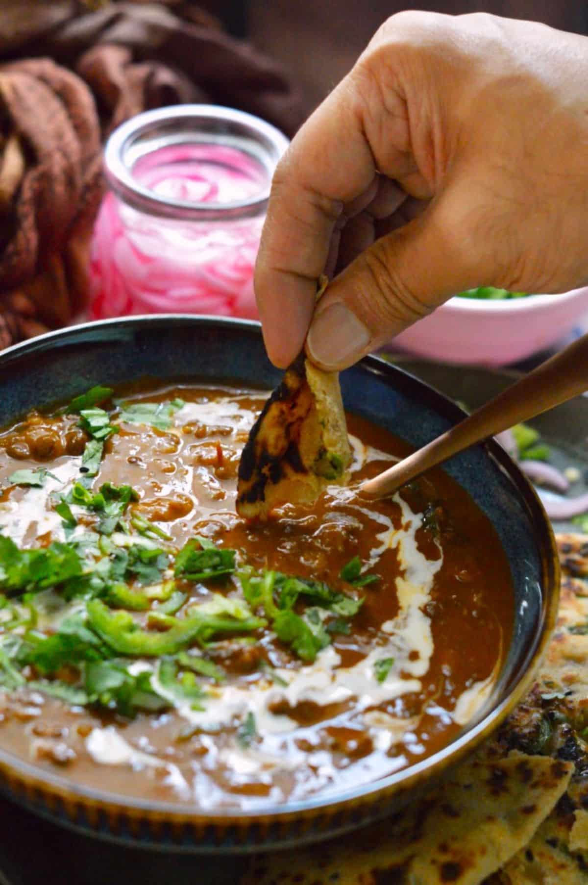 Dal Makhni dish in a blue bowl with a spoon.