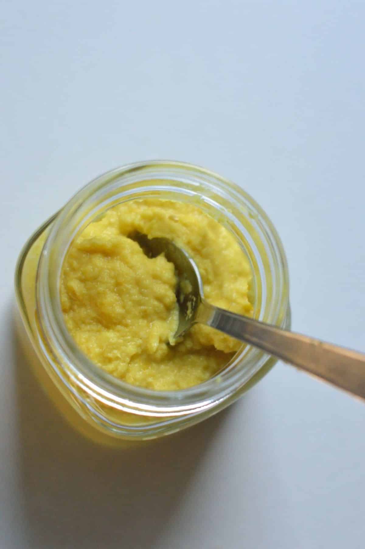 Ginger Garlic Paste in a glass jar with a spoon.