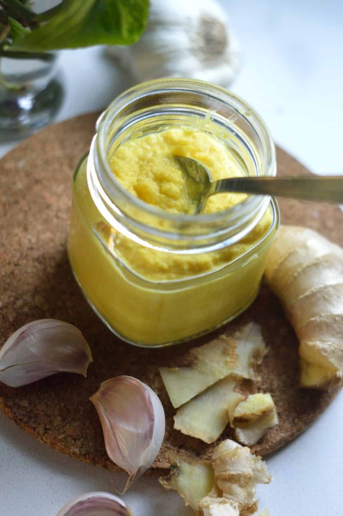 Ginger Garlic Paste in a glass jar with a spoon.