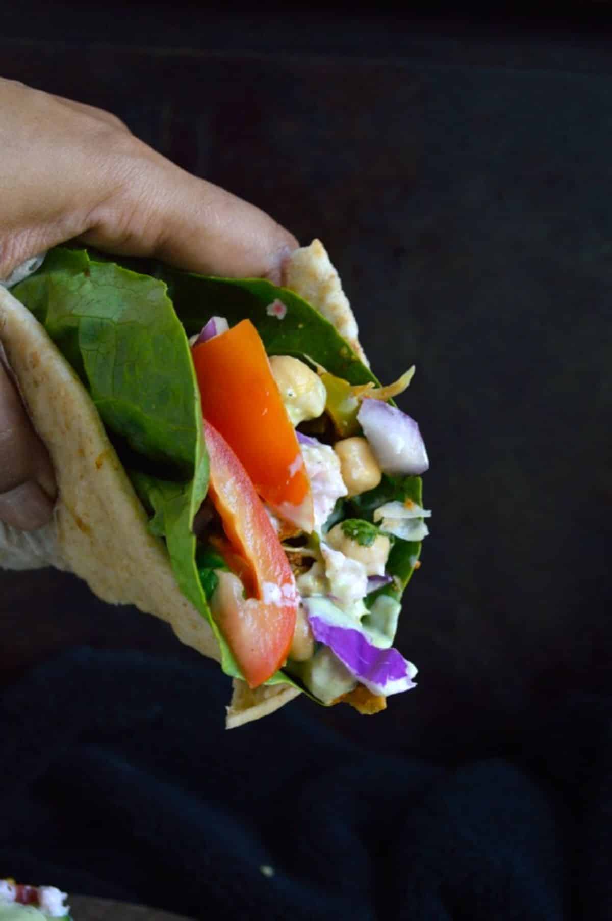 Jackfruit Curry Gyro held by hand.