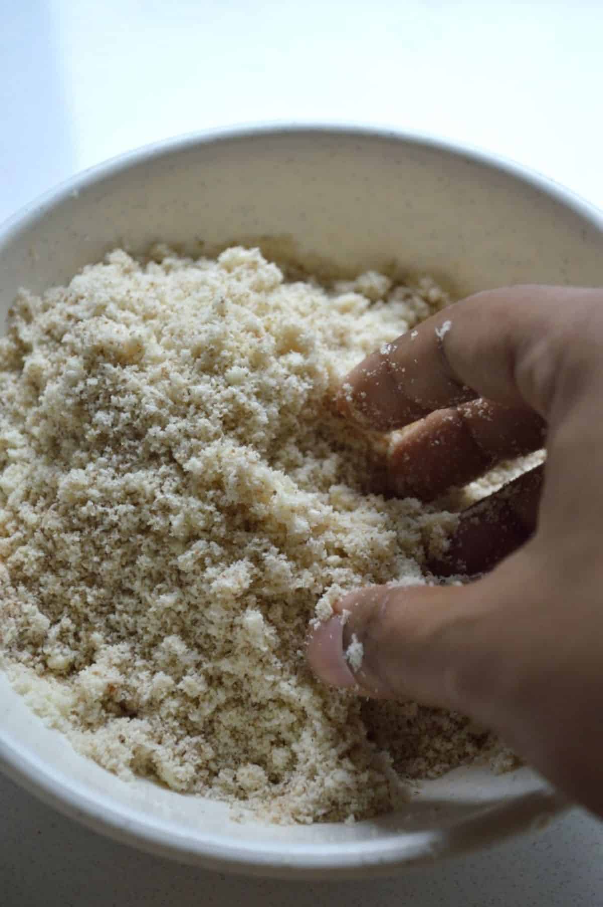 Hand mixing ingredients in a bowl.