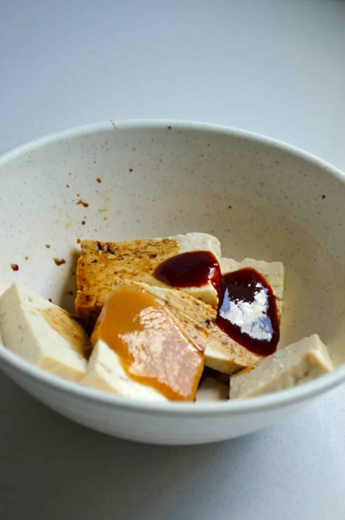 Sliced Tofu with sauce in a white bowl.