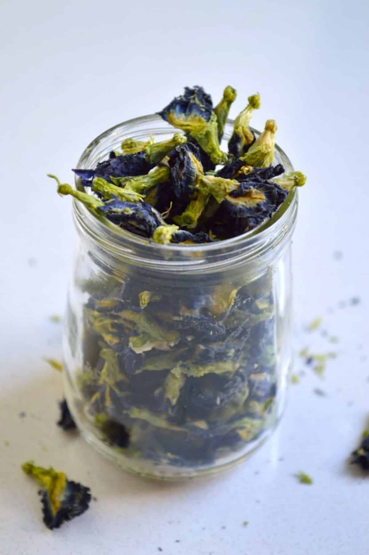 A glass jar full of dried pea flowers.