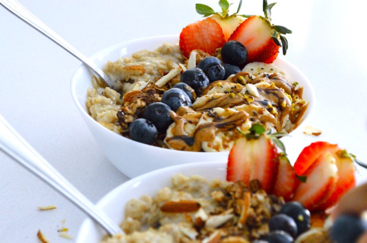 Pressure Cooker Oatmeal in white bowls with fruits on the top.