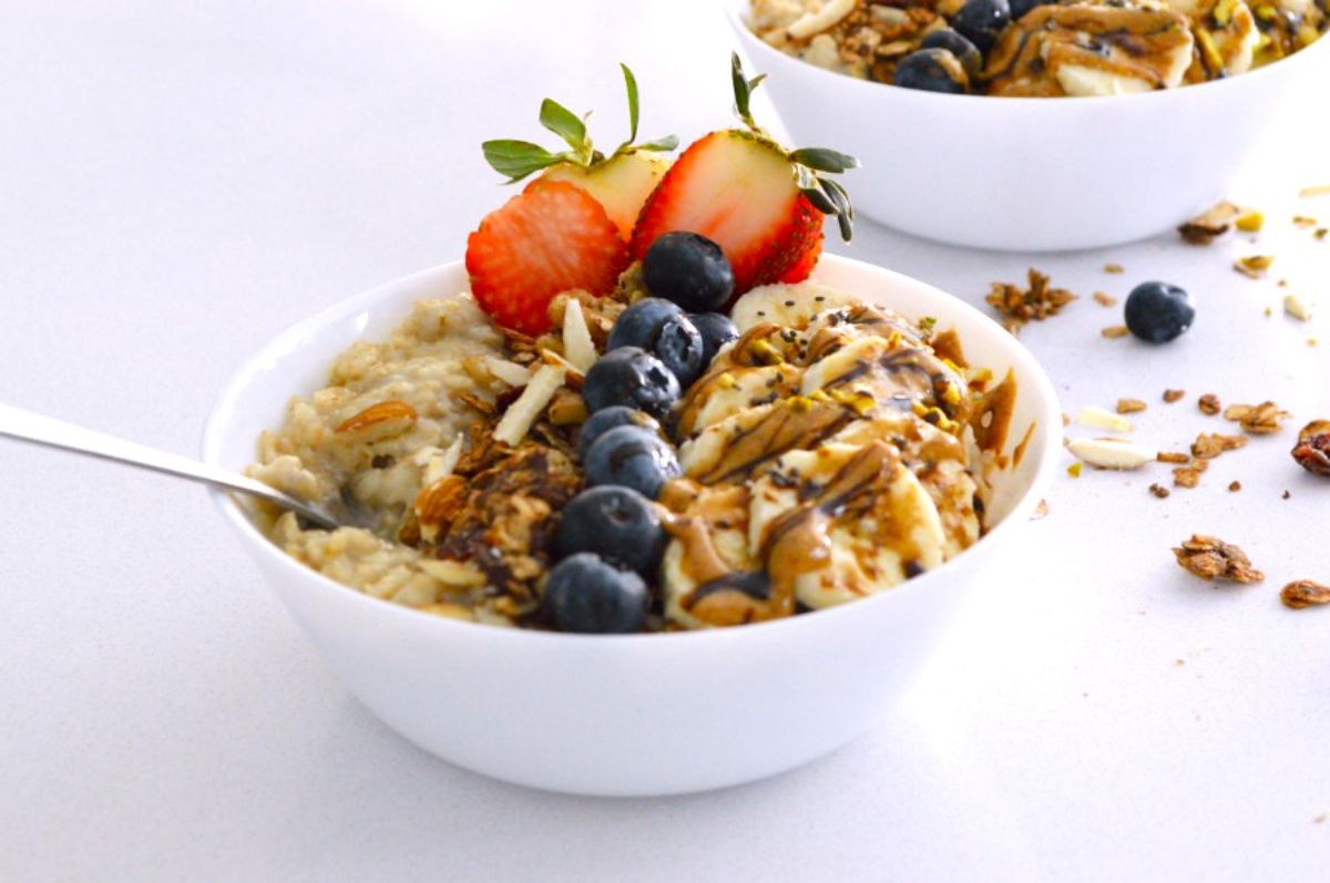 Pressure Cooker Oatmeal in a white bowl with fruits on the top.