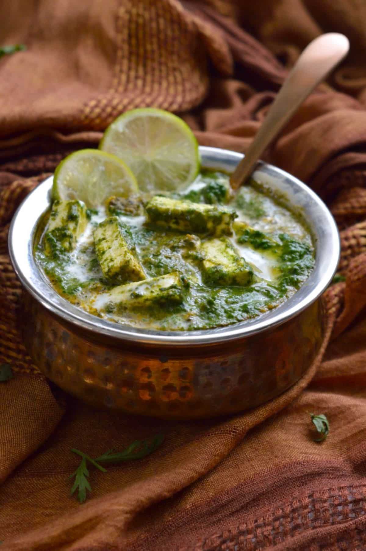 Saag Paneer dish in a bowl with a spoon.