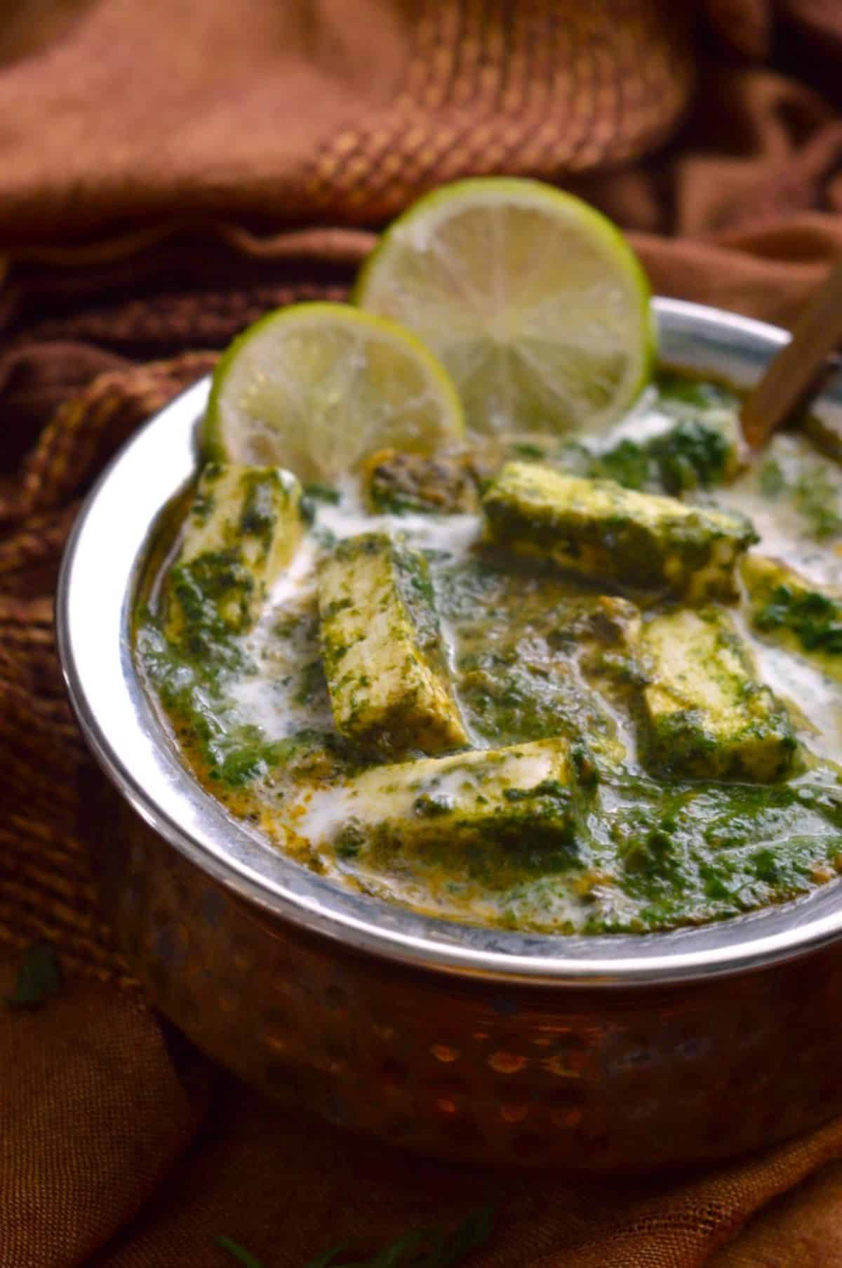 Saag Paneer dish in a bowl with a spoon.