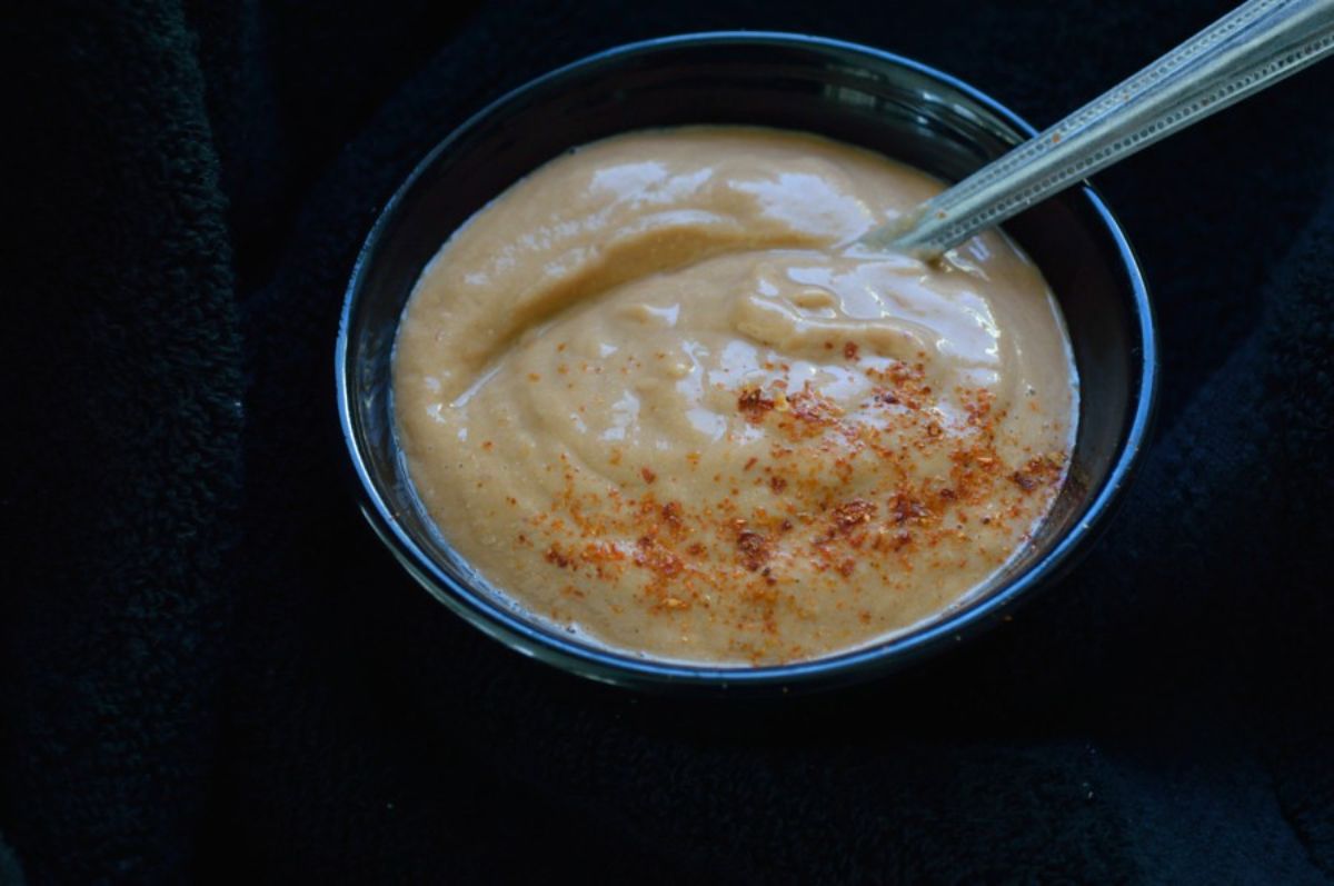 Spicy Cashew Chutney in a black bowl with a spoon.