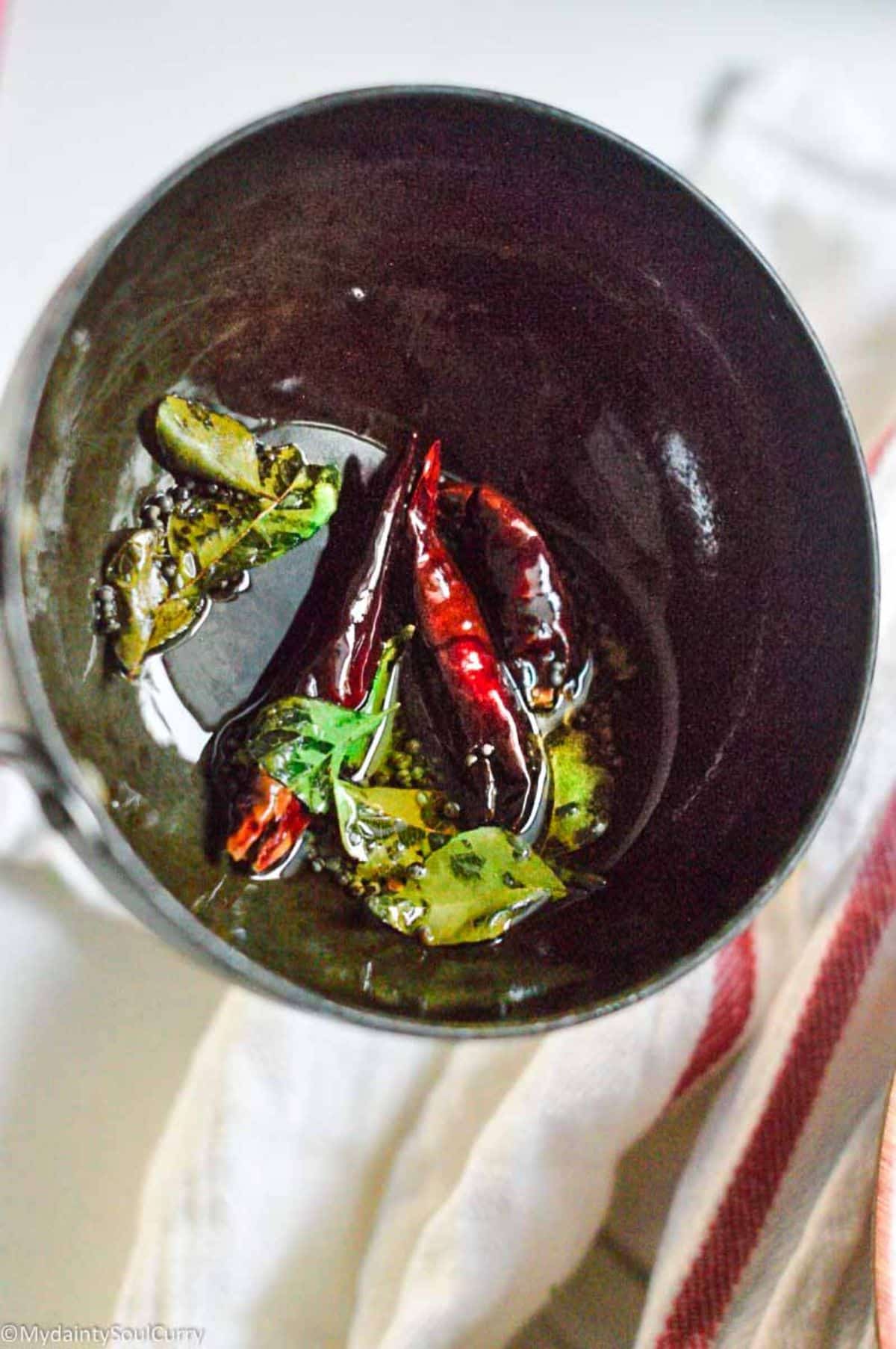 A black bowl with chili peppers.