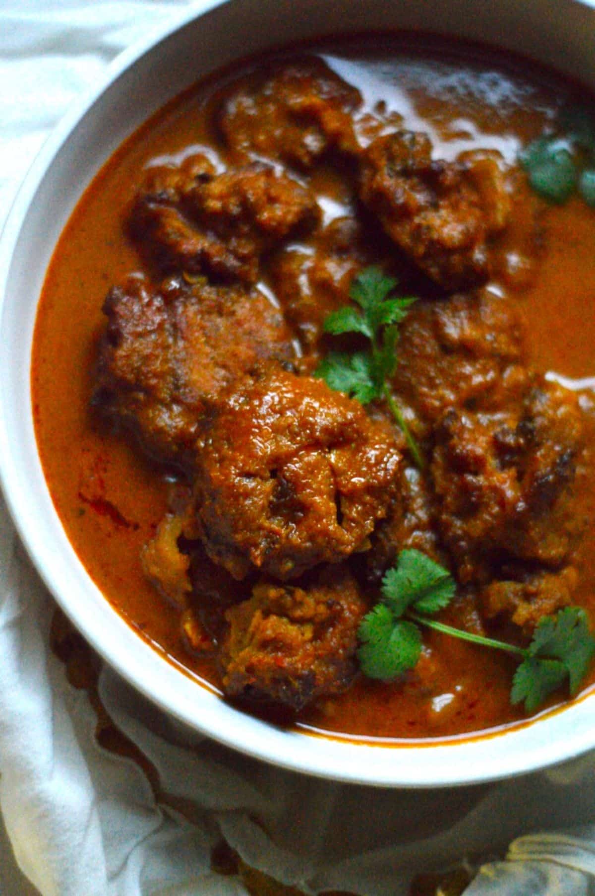 Vada Curry dish in a white bowl.