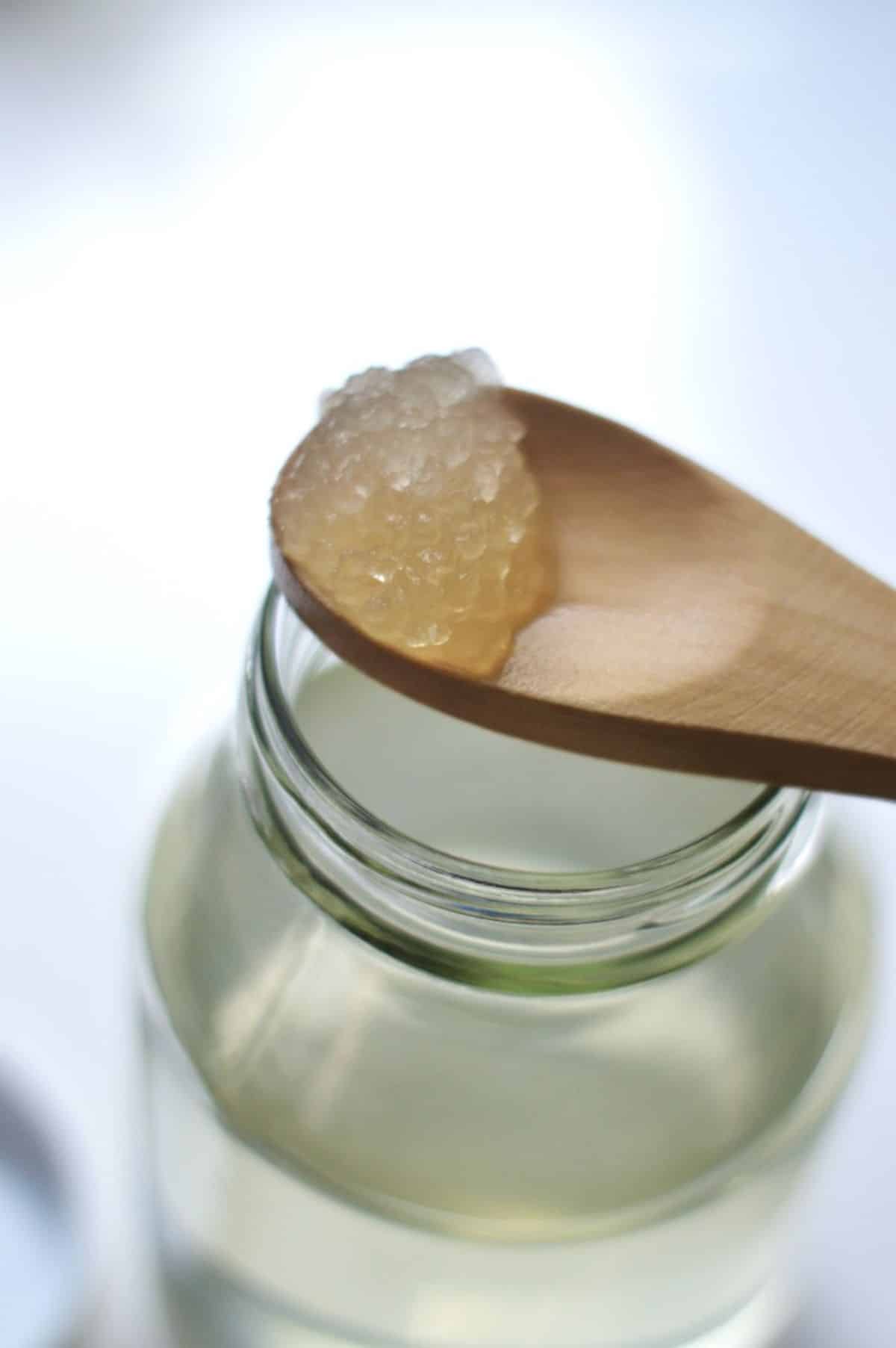 Adding kefir grains in a glass jar.