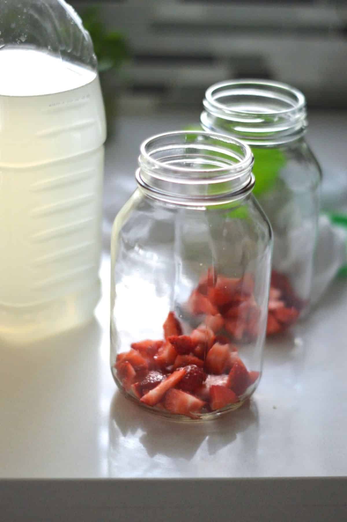 Chopped strawberries in a glass jars.
