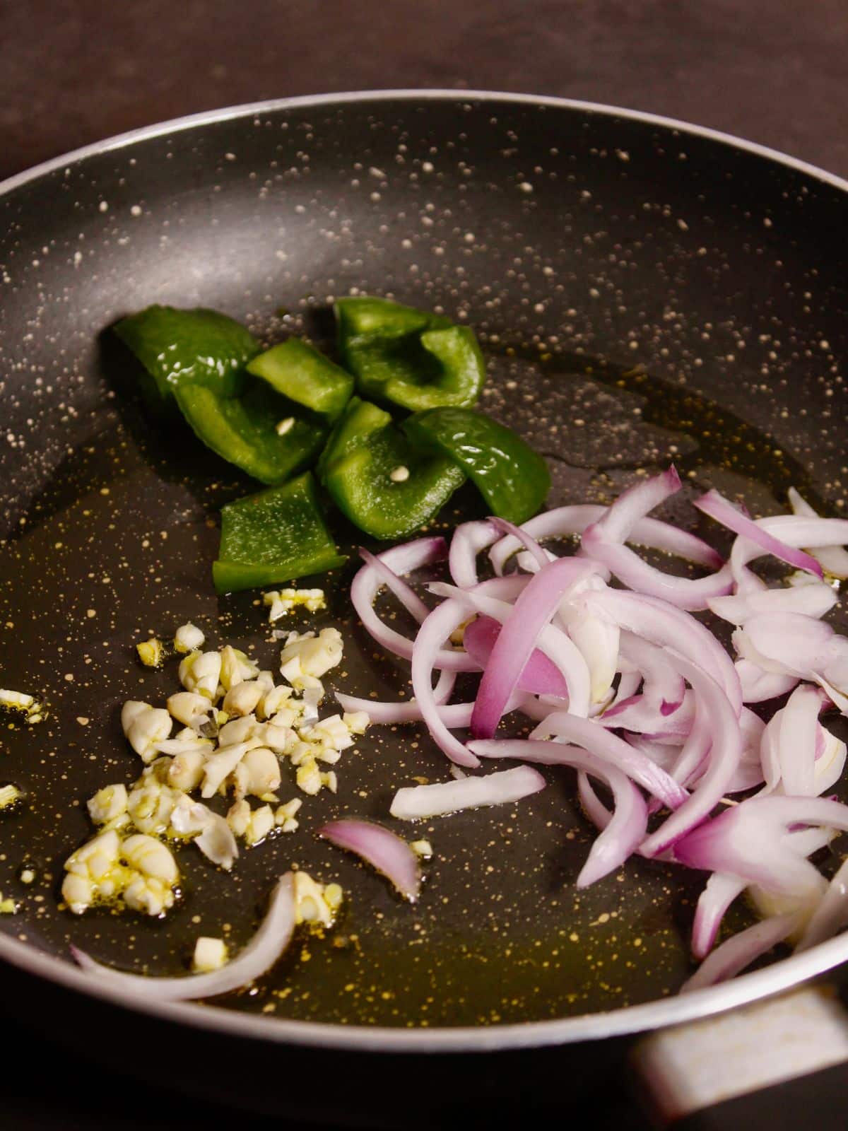 add chopped onions, capsicum and garlic in a pan and saute 