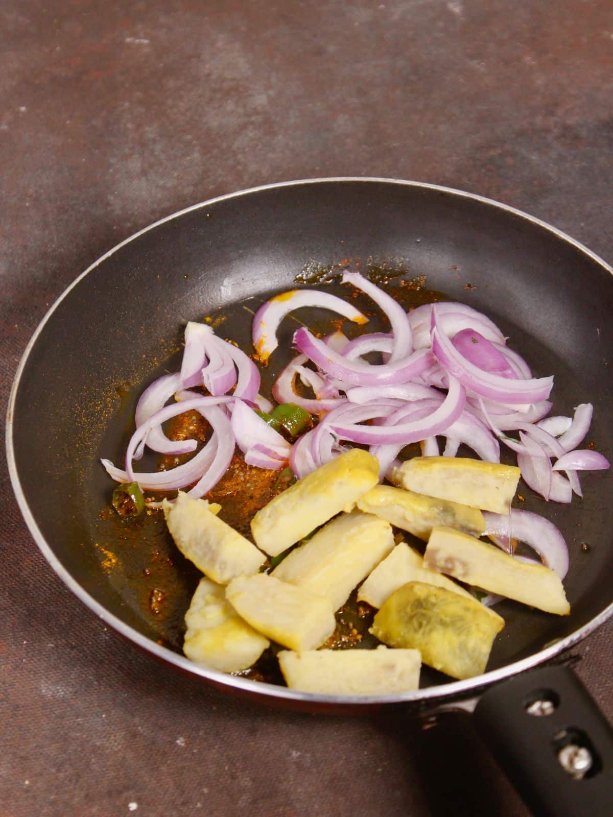 add boiled yams with sliced onions to the pan 