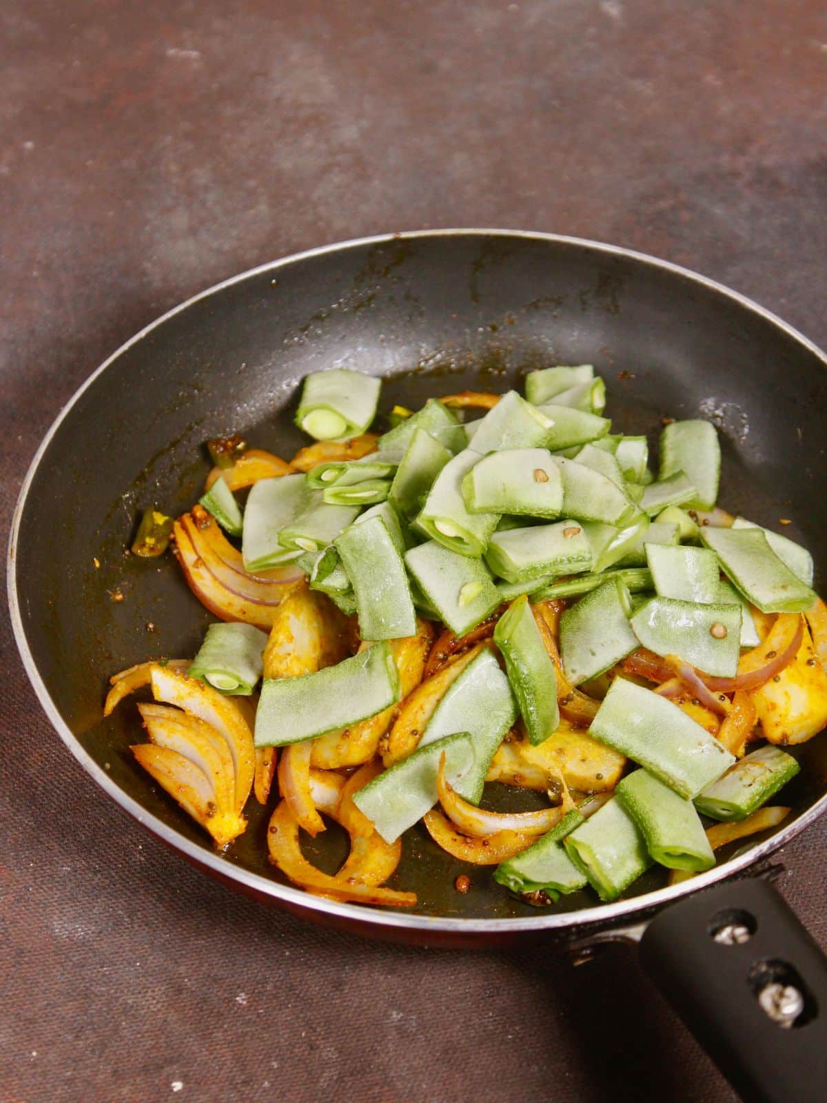 add chopped broad beans to the pan and mix well 