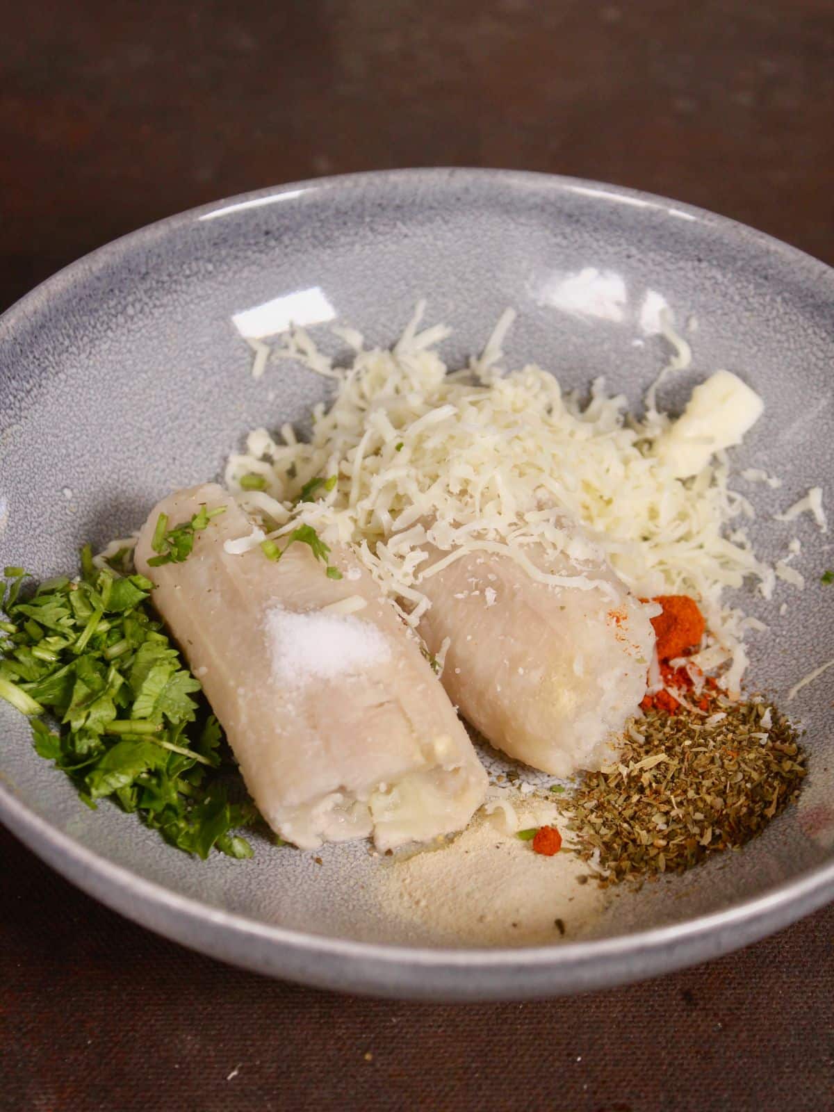 all the ingredients of raw banana fritters in a bowl 