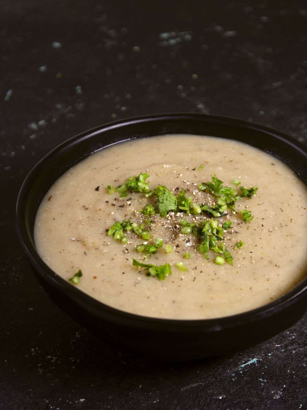 garnish creamy vegan potato soup with chopped coriander leaves 