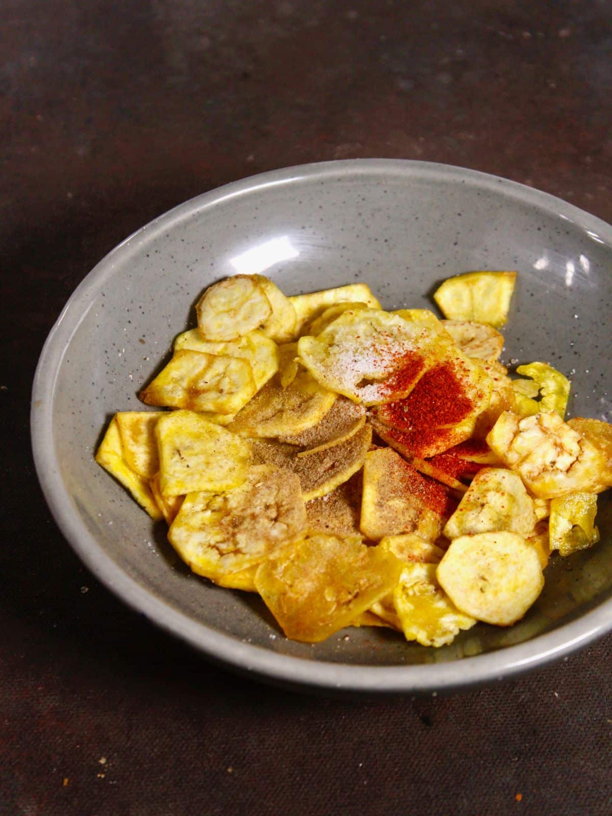 add powdered spices over the banana chips and mix well 