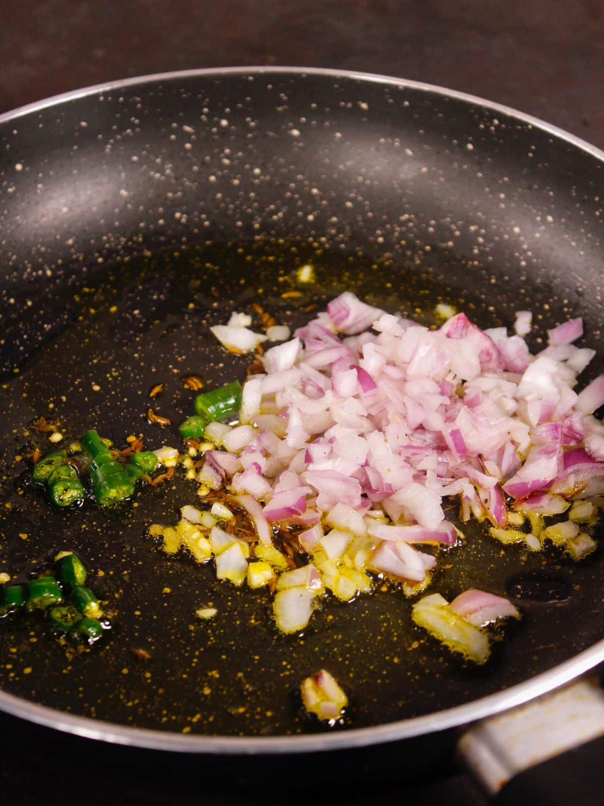add chopped onions and chilies and saute  