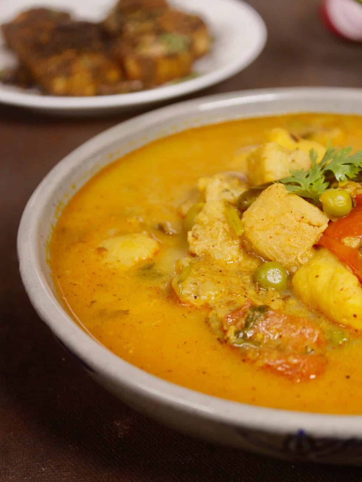 half bowl view of raw banana and yam curry