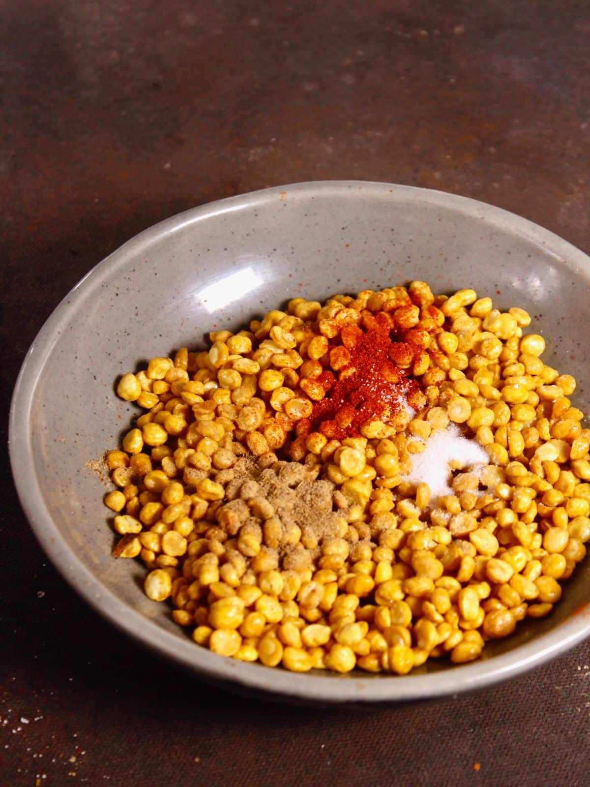 add powdered spices to the fried chana dal in a bowl 