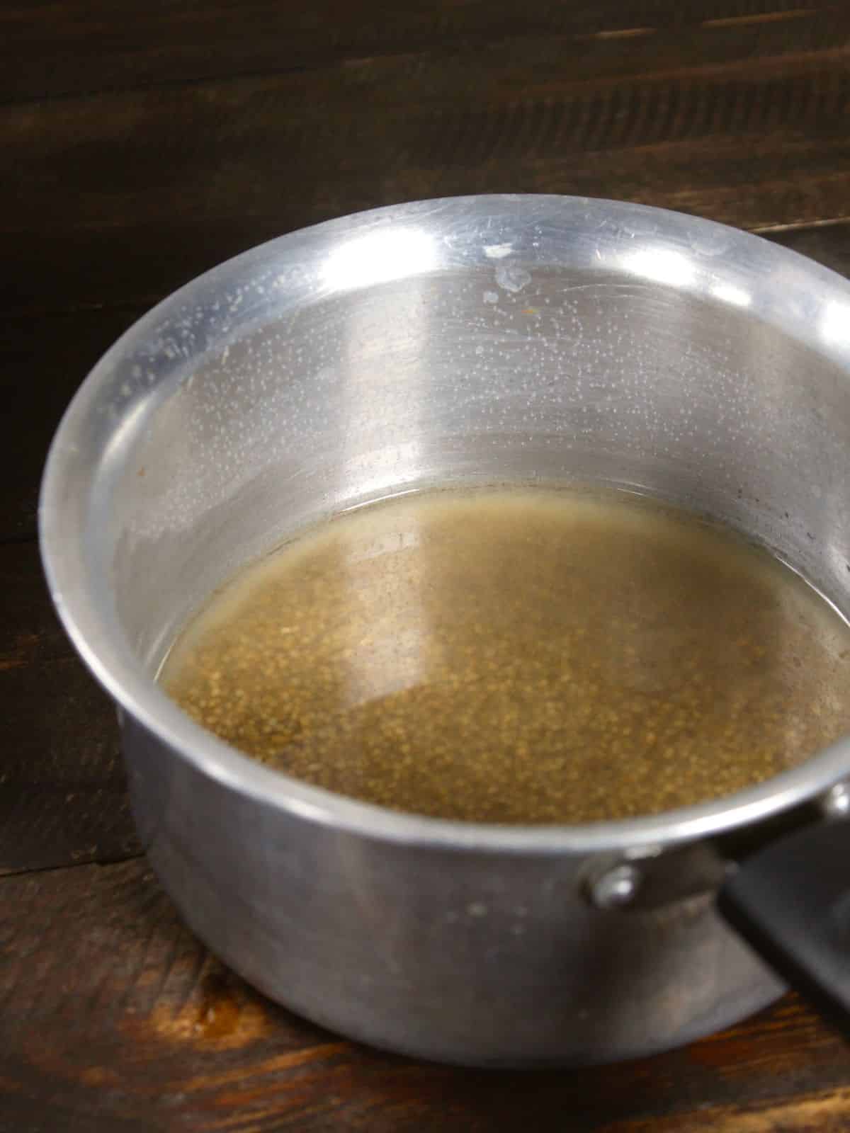 boil soaked millet in a deep vessel 