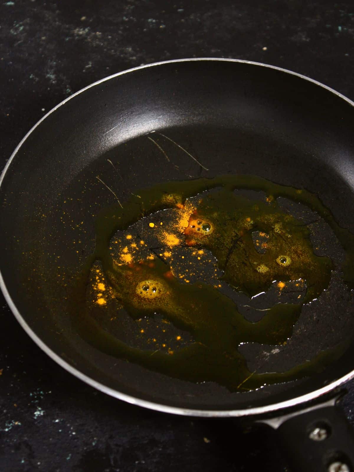 add oil and turmeric powder into the pan and saute 